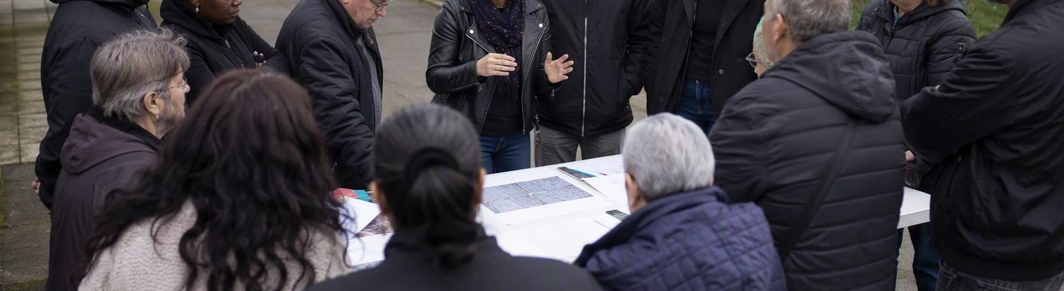 Rassemblement d'habitants autour d'une table, à l'écoute